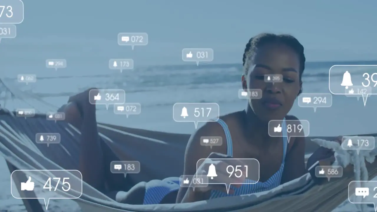 Animation of social media reactions over happy african american woman in hammock on beach