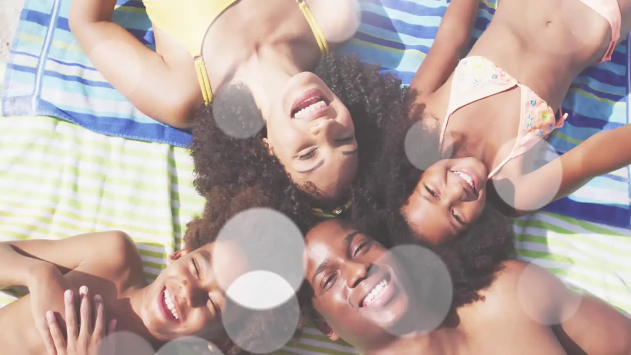 Animation of light spots over happy african american family at beach