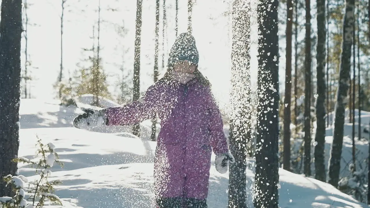 Happy child throwing snow into the air on sunny day