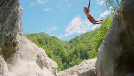 Woman freedom or cliff jumping in water