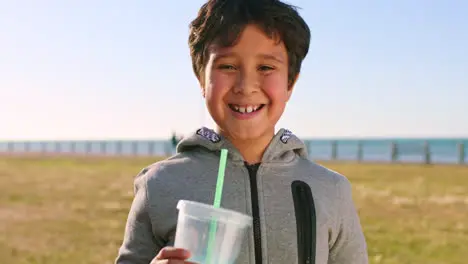 Boy face and drinking by the ocean on a leisure