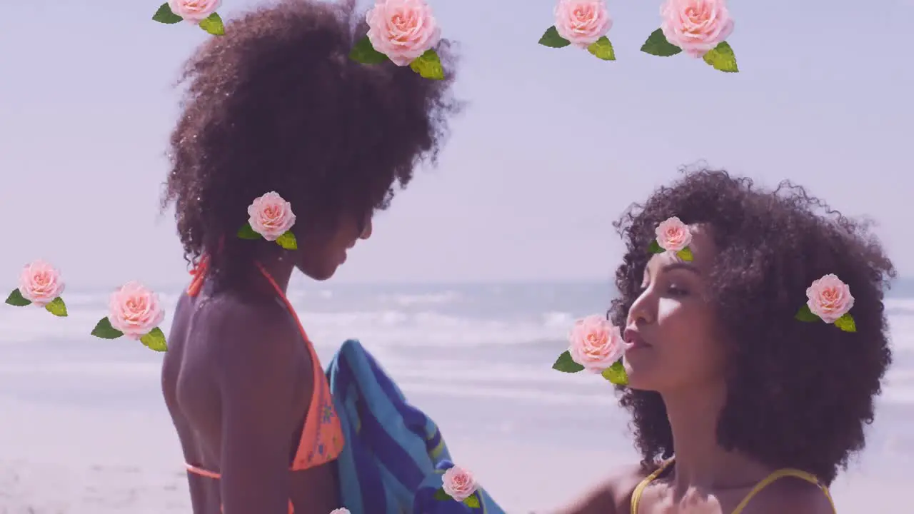 Animation of flowers over happy african american mother with daughter on sunny beach