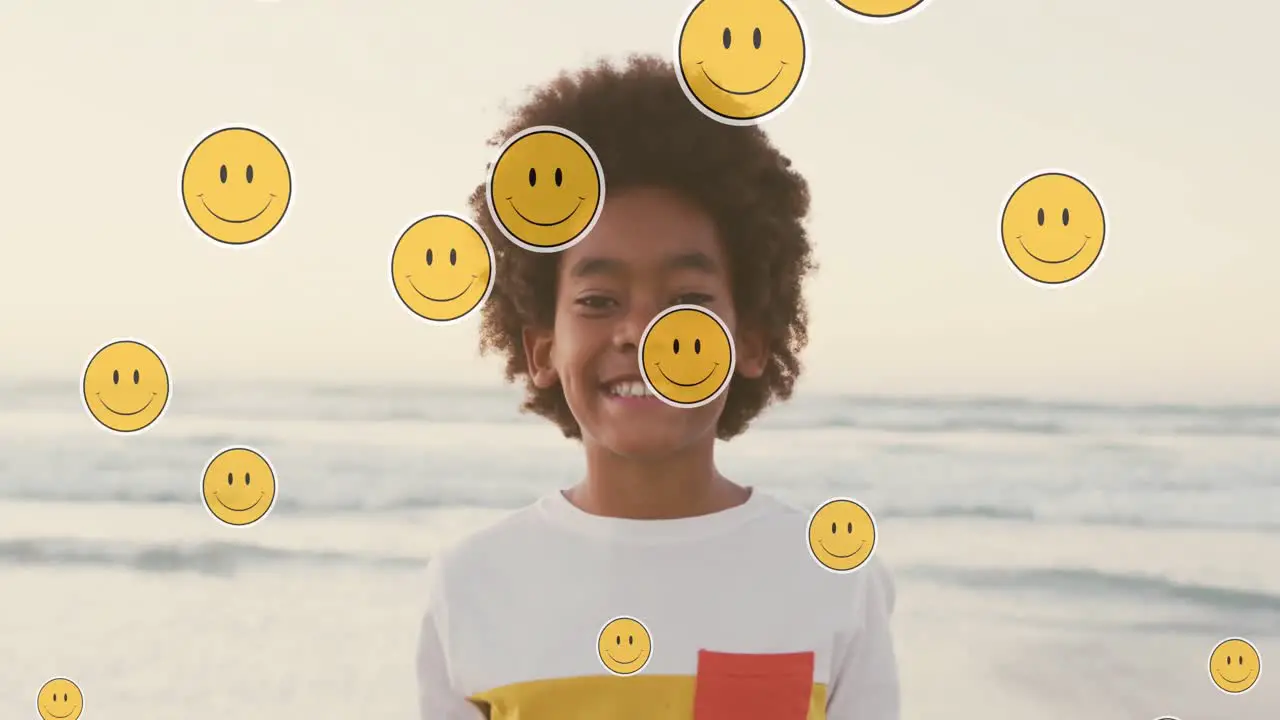 Animation of emoji icons over happy african american boy on sunny beach