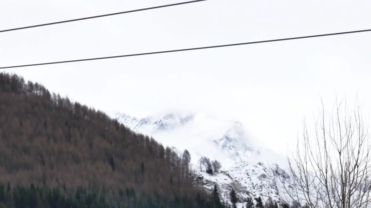 static 4k video of two chair lifts passing by with mountain background in a ski resort