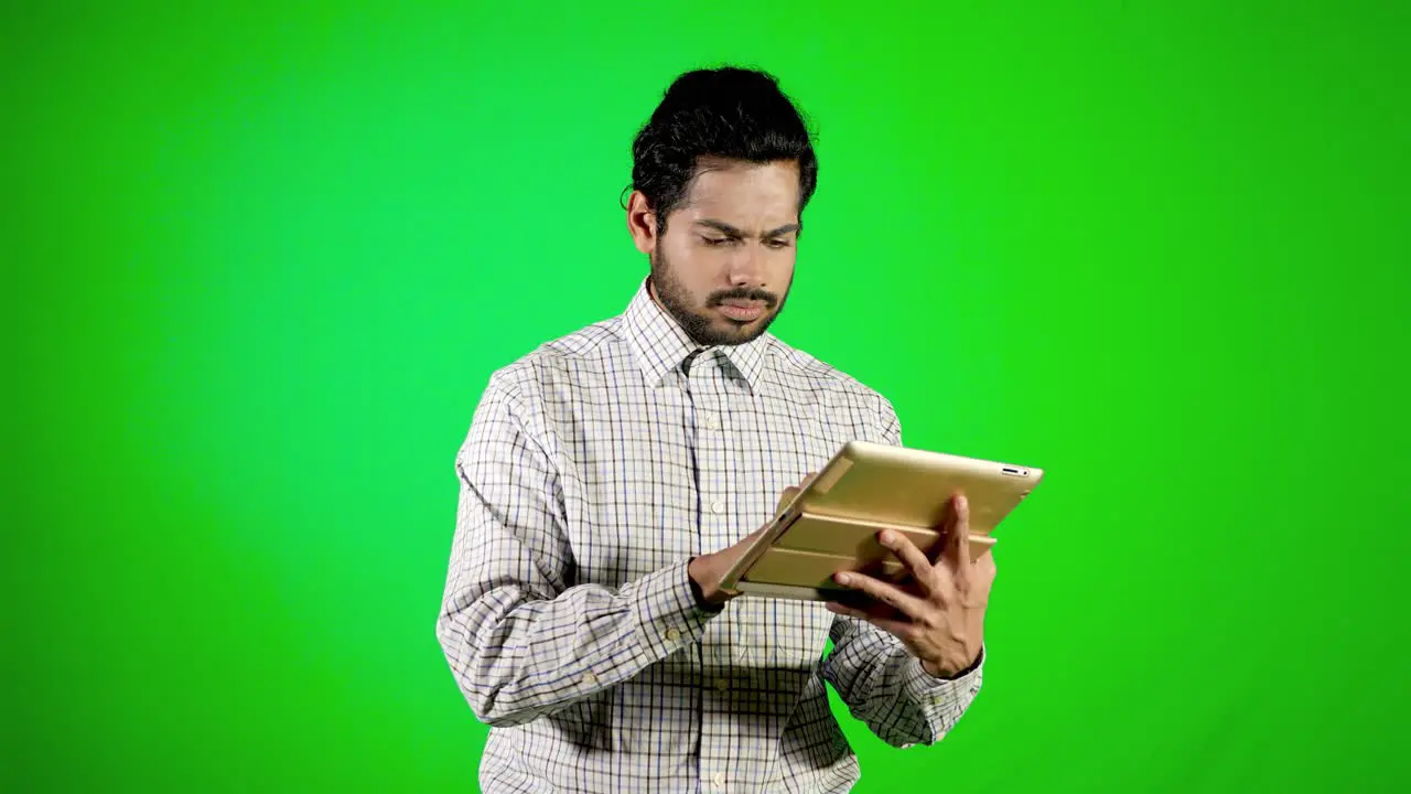 guy using mobile tablet with green screen and green background indian guy with green screen