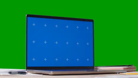 Blue Screen Laptop With Bills On Table With Green Screen Background