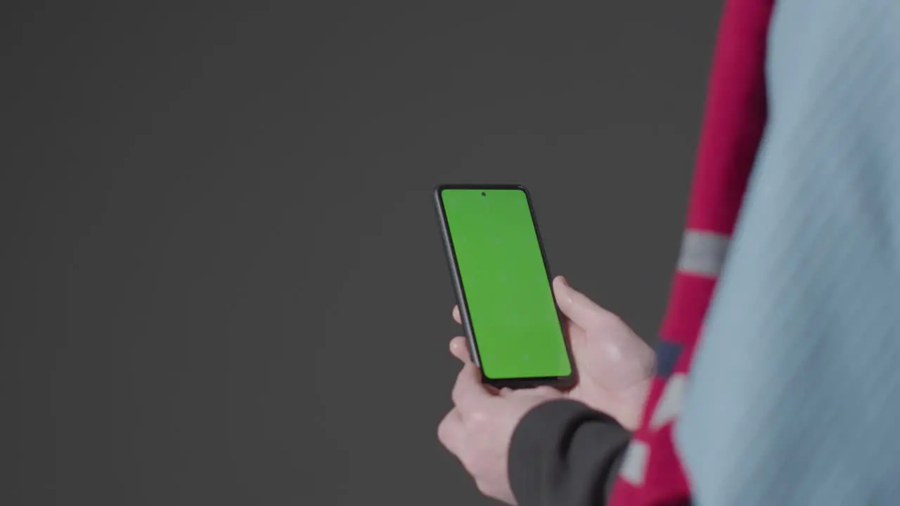 Close Up Of Cold Person Wearing Blanket Holding Green Screen Mobile Phone Trying To Keep Warm In Energy Crisis 1