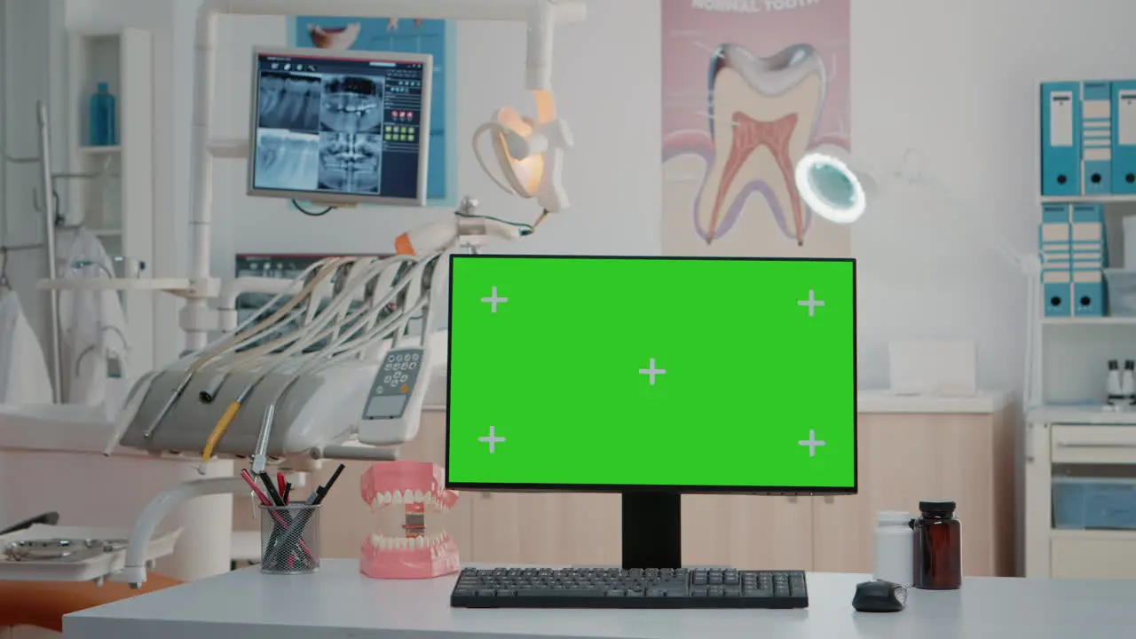 Nobody in dentist office with horizontal green screen on computer