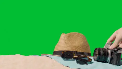 Summer Holiday Concept Of Sunglasses Sun Hat Camera Beach Towel On Sand Against Green Screen 4