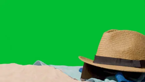 Summer Holiday Concept Of Sunglasses Sun Hat Mobile Phone Beach Towel On Sand Against Green Screen 1