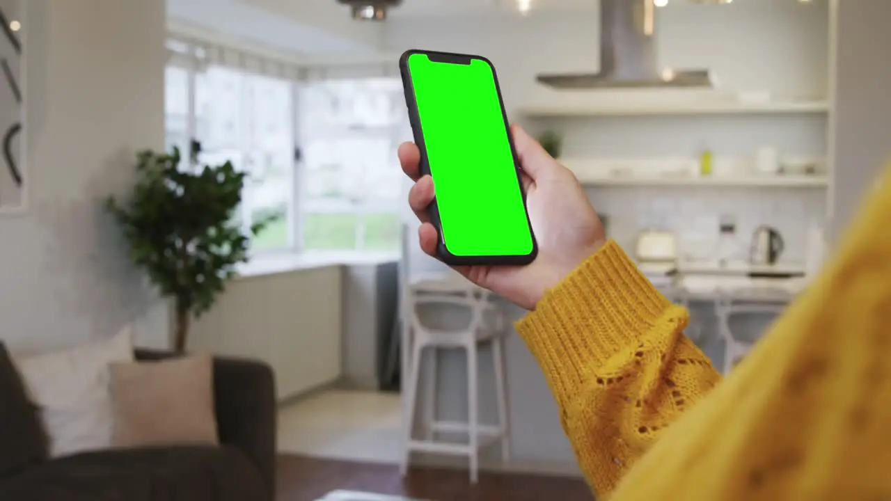 Woman using smartphone in kitchen