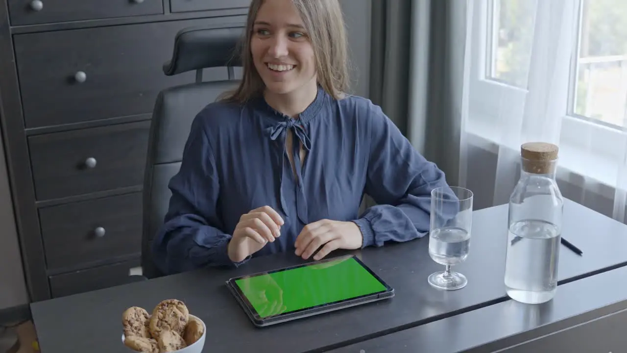 Laughing woman swiping on tablet green screen