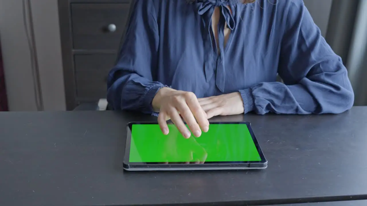 Woman tapping on tablet and zooms in green screen closeup