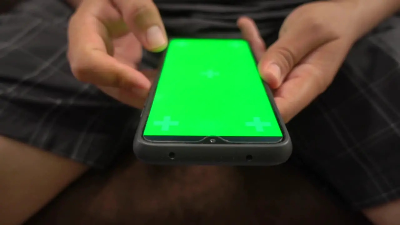 Frontal view of hands taping on an smartphone chroma screen