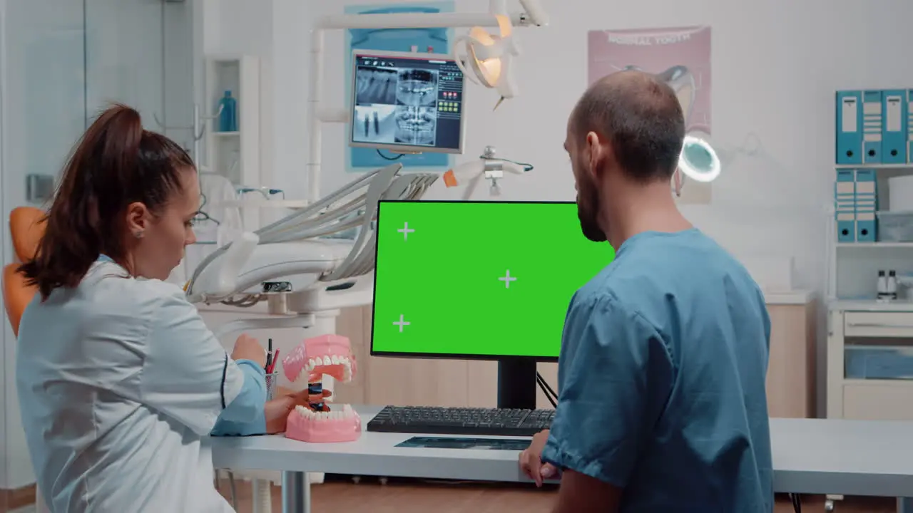 Nurse and dentist examining teeth layout using green screen