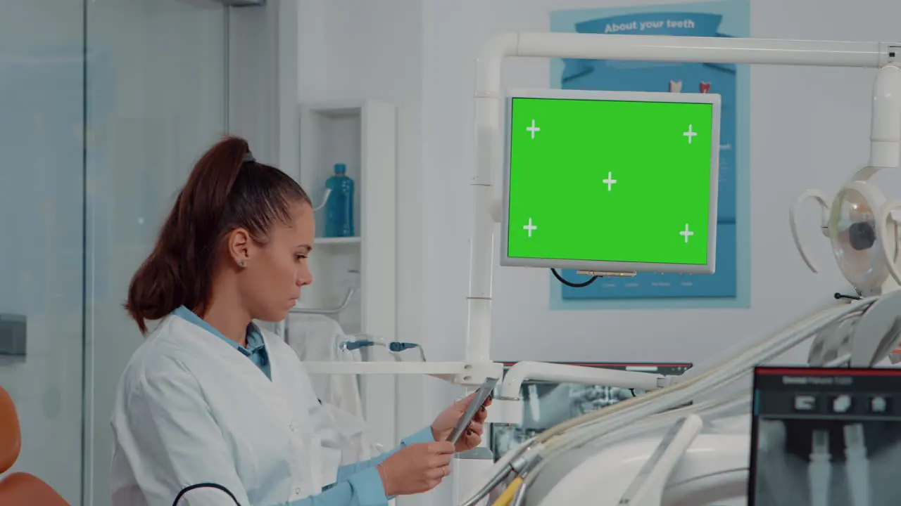 Dentist analyzing horizontal green screen on monitor