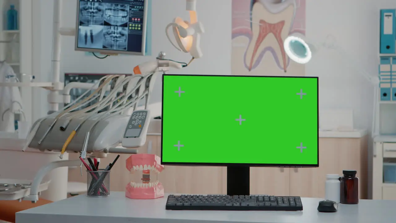 Monitor with green screen on desk in empty dentist office