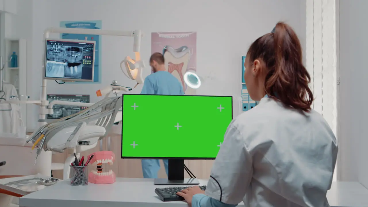 Woman using keyboard and computer with green screen