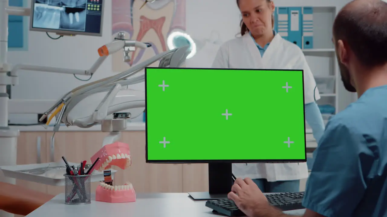 Man nurse looking at horizontal green screen on monitor