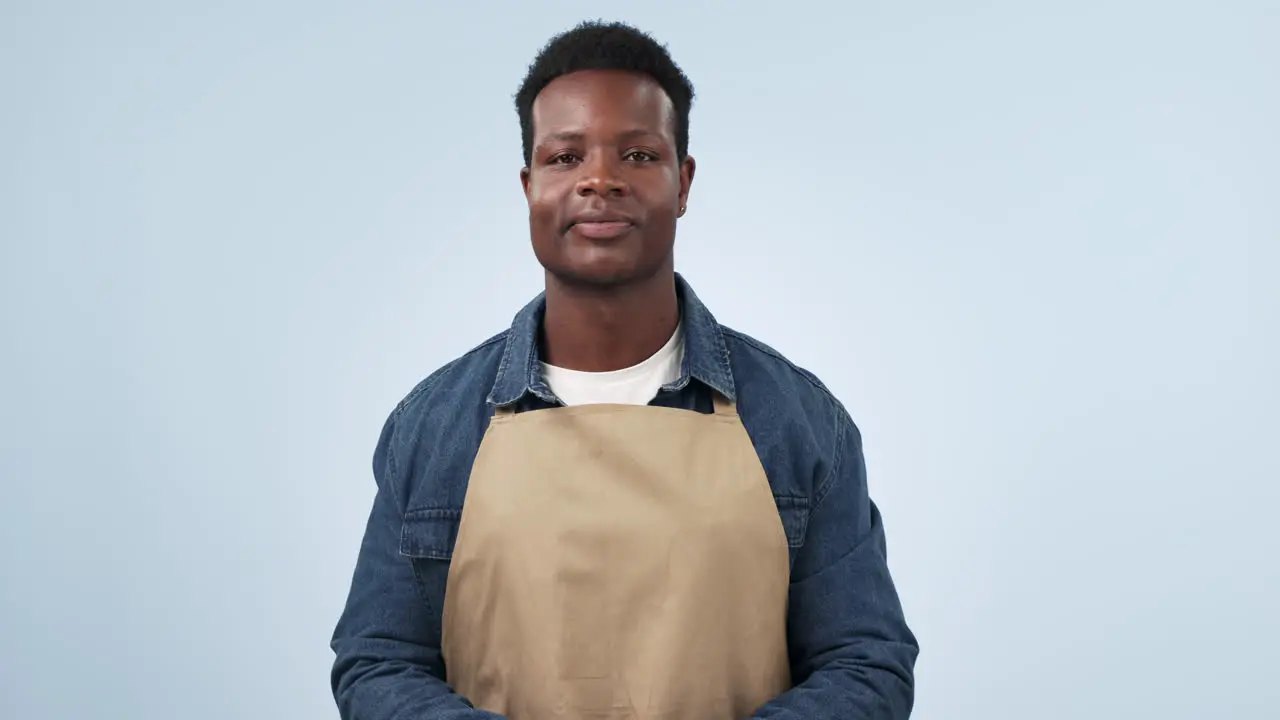 Waiter man thumbs up and smile in studio