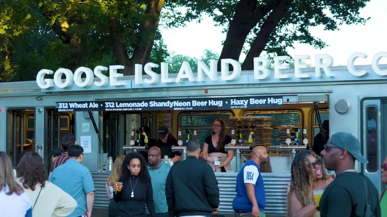 people are in line purchasing alcoholic drinks from a goose island beer truck this outdoors during the festive event the Taste of Chicago