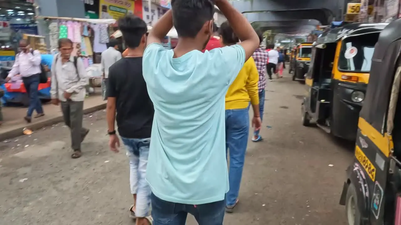 Mumbai India 20 August 2023 People walking through a market beside lines of auto rickshaws and stalls in Mumbai India