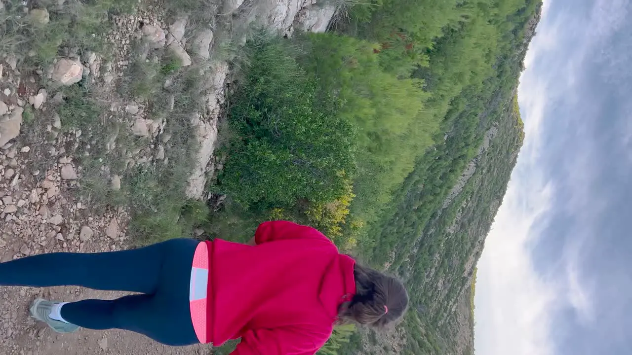 Vertical Woman hiking on trail by the Mediterranean sea