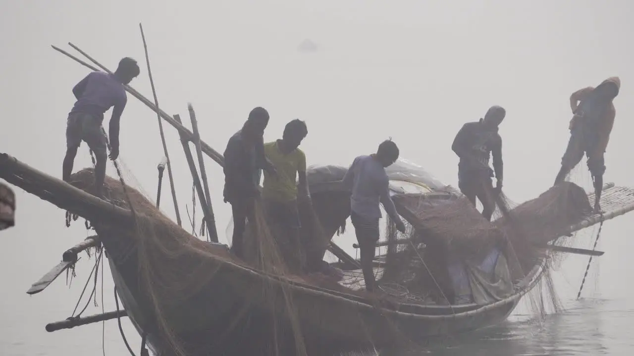 Bangladeshi fishermen pulling nets from the river water