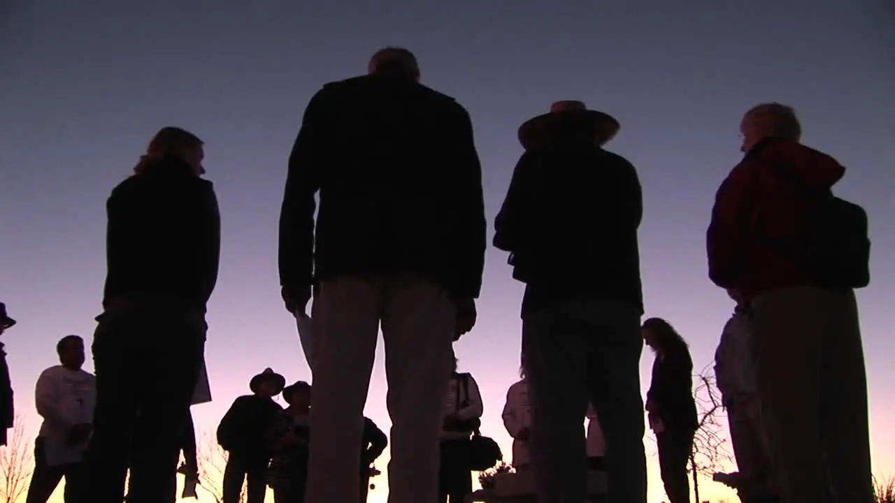 A group of people stand in a circle talking