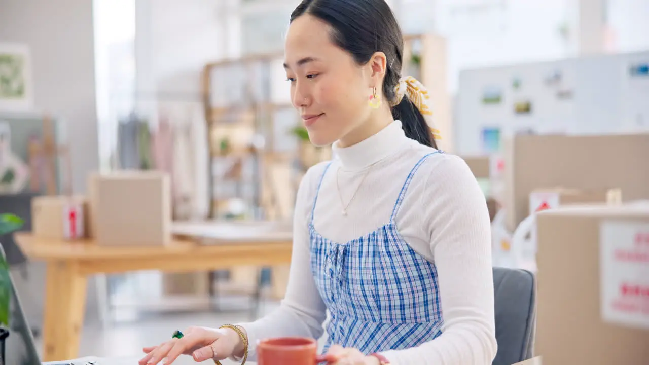 Ecommerce Asian woman at laptop drinking coffee