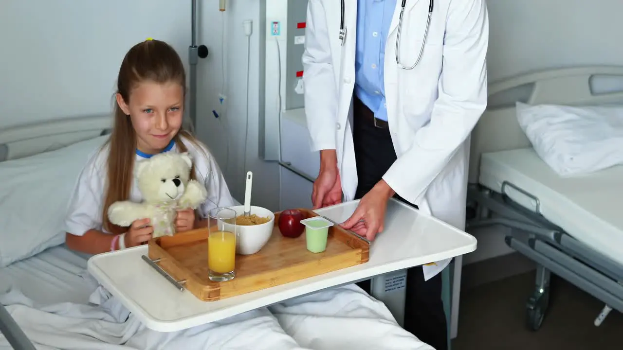 Doctor serving food to sick girl