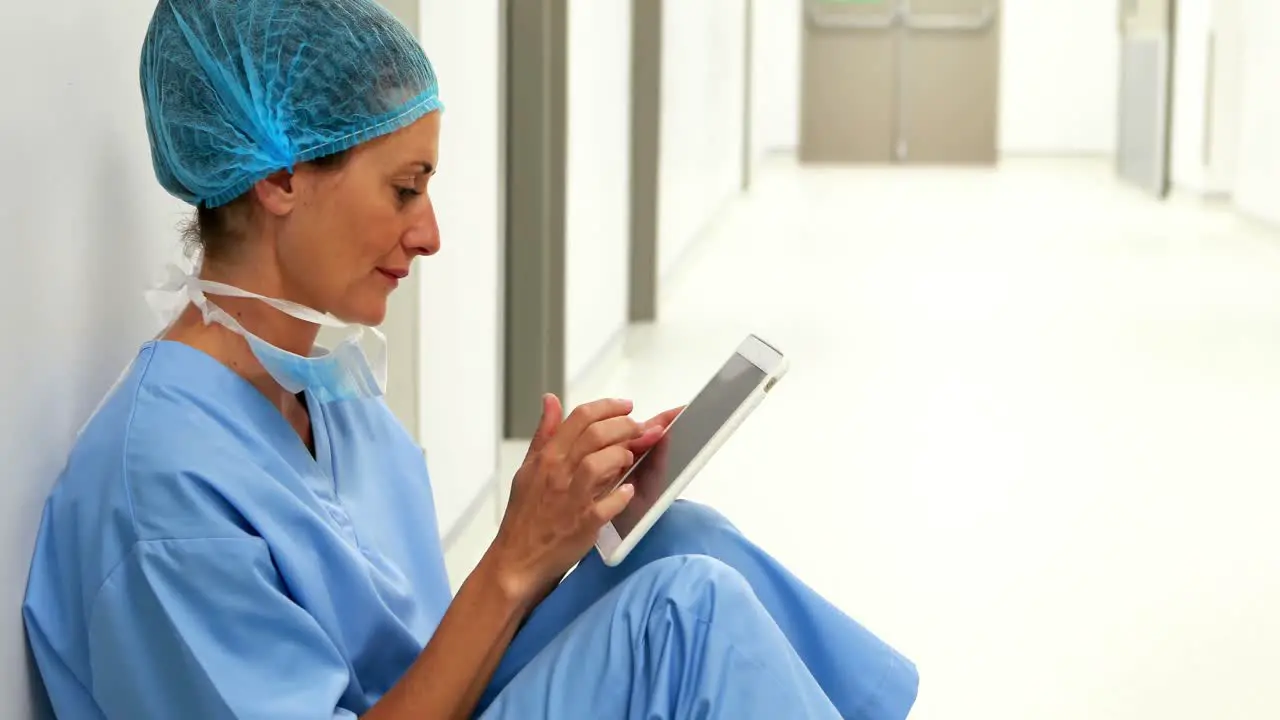 Surgeon sitting on floor and using digital tablet