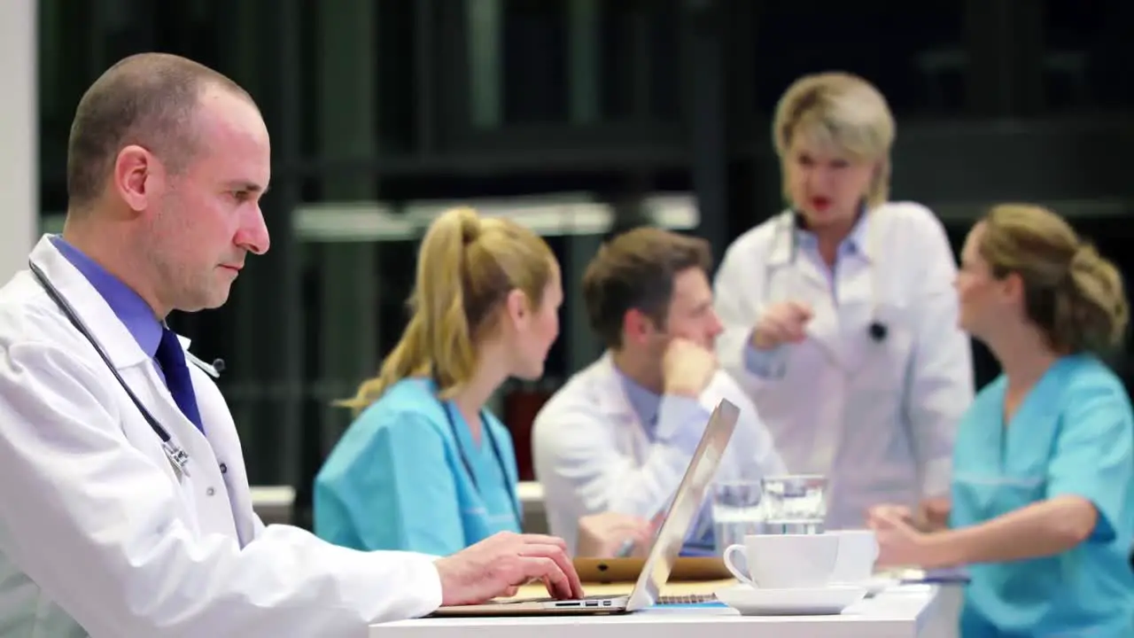 Doctor using laptop in conference room