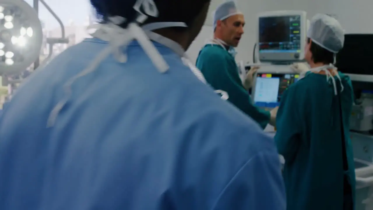 Surgeon using digital tablet while colleagues interacting in the background