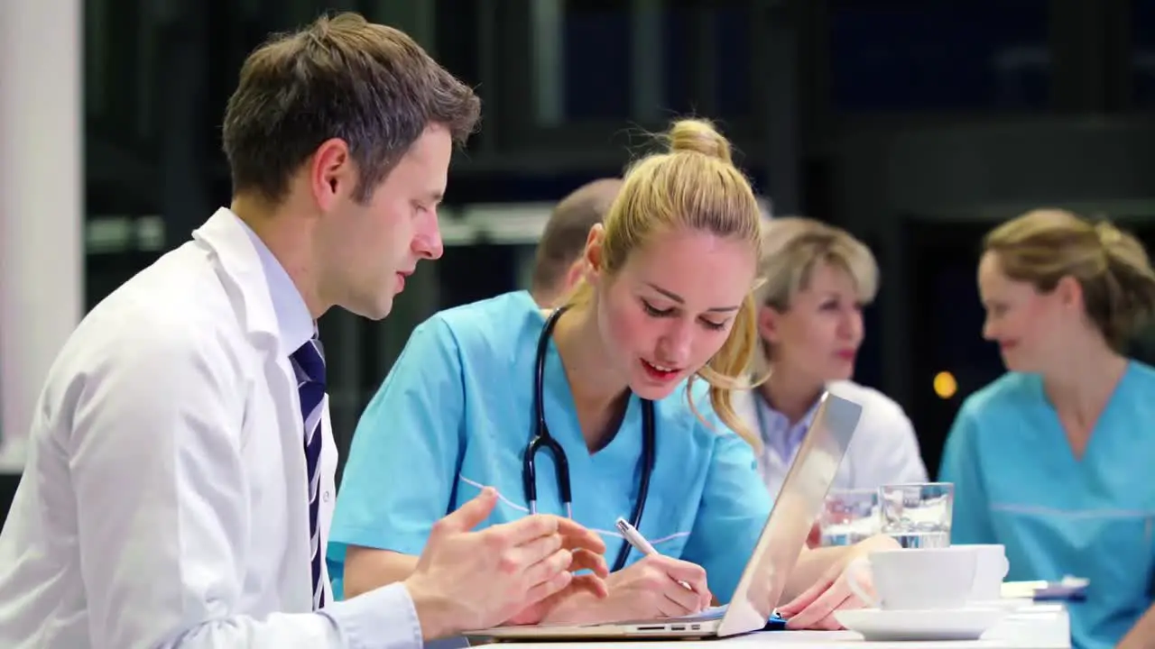 Doctors and nurse discussing with each other in conference room