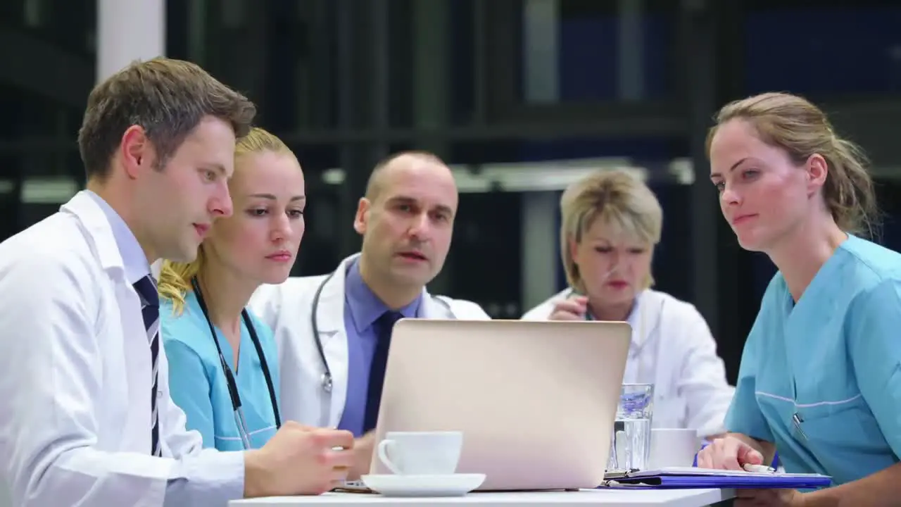 Team of doctors discussing over laptop in conference room