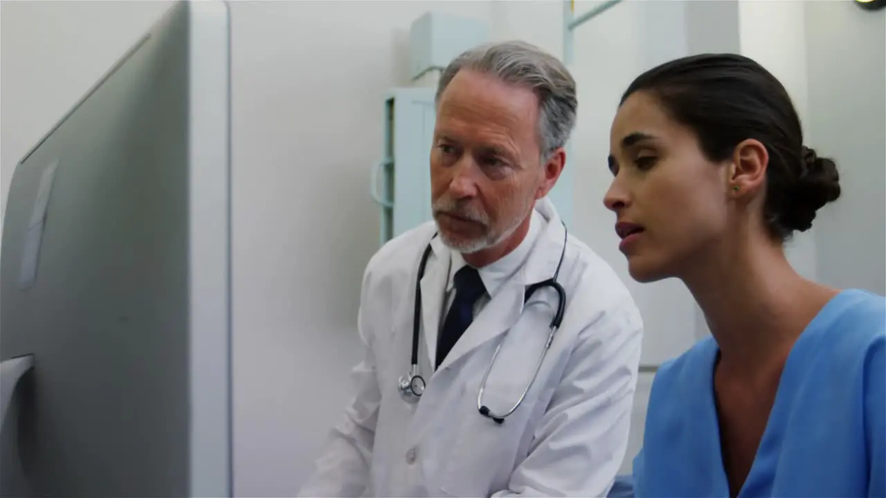 Surgeon and colleague discussing computer