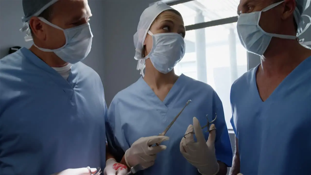 Surgery team discussing while operating a patient in an operating room