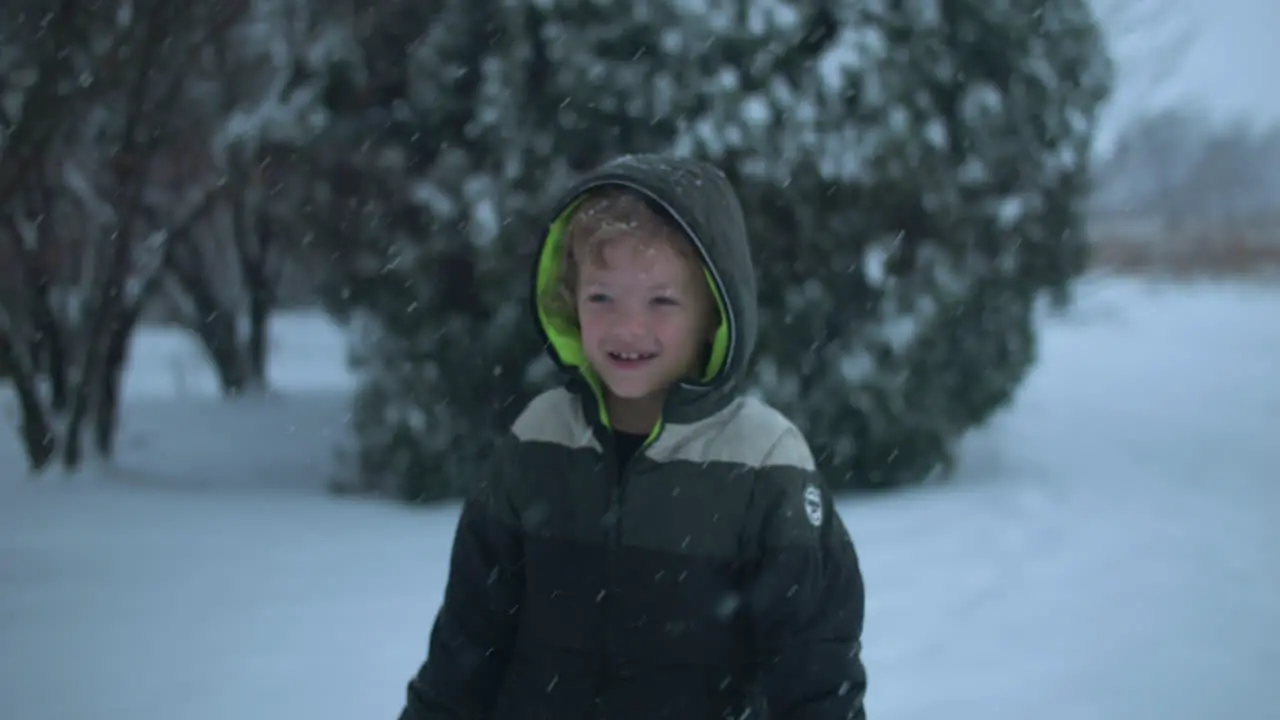 Happy kid on Christmas morning playing in snow