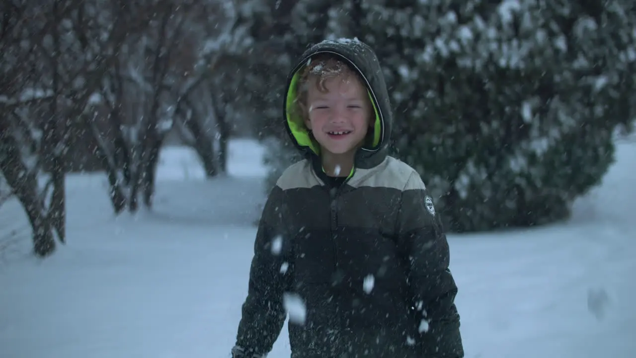 Happy kid on Christmas morning playing in the snow