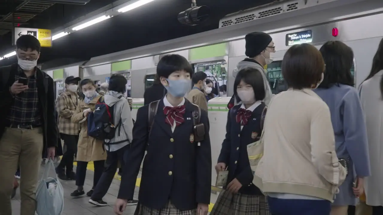 Two Student Kids Getting Off From The Train Wearing Face Mask During Corona Virus Pandemic In Tokyo Japan