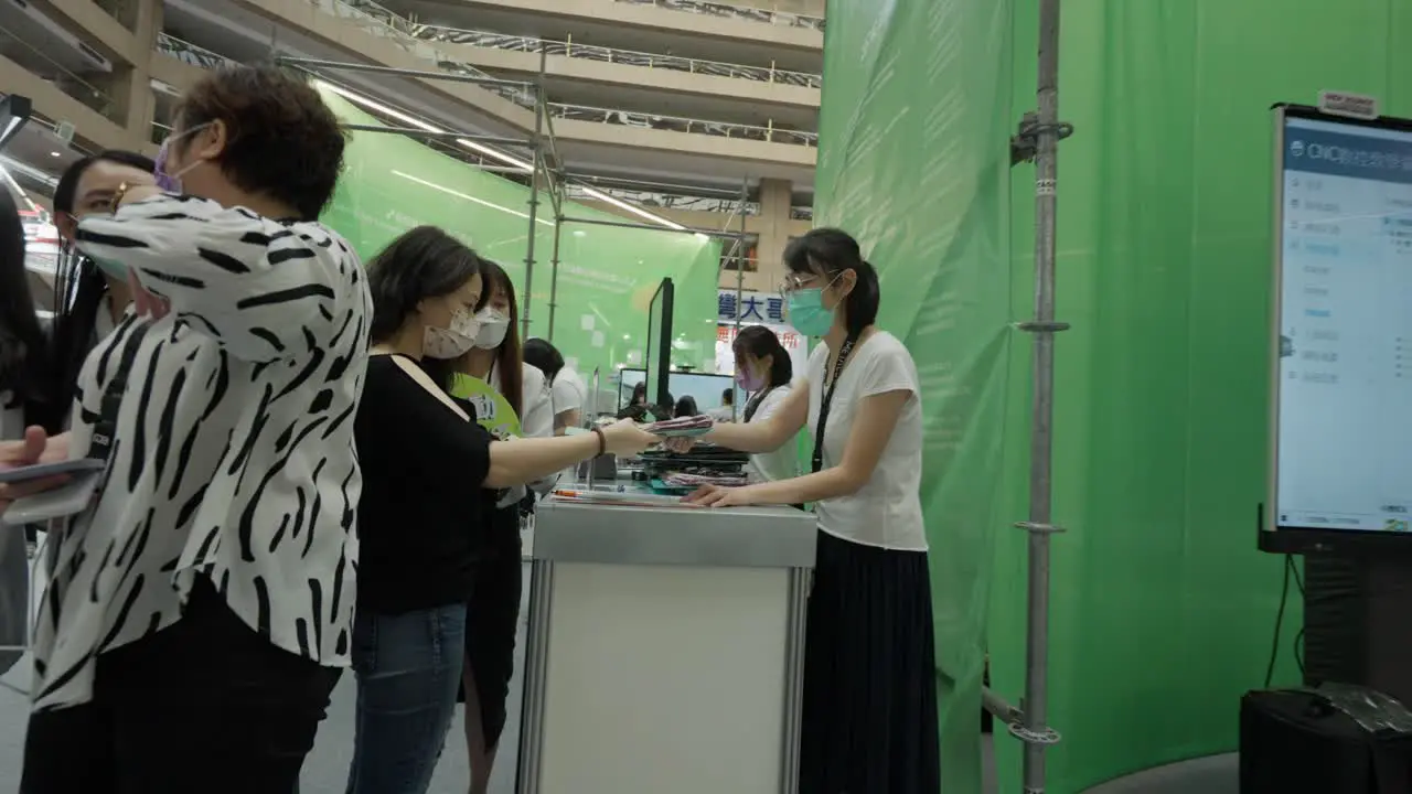 Lady receiving a brochure in a tech expo booth