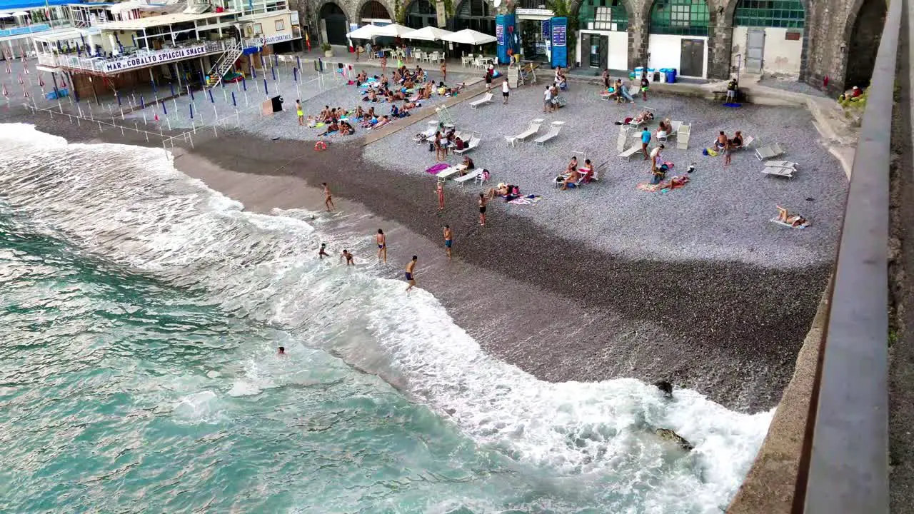 people playing on the beach with a ball at late sunset in Amalfi Italy