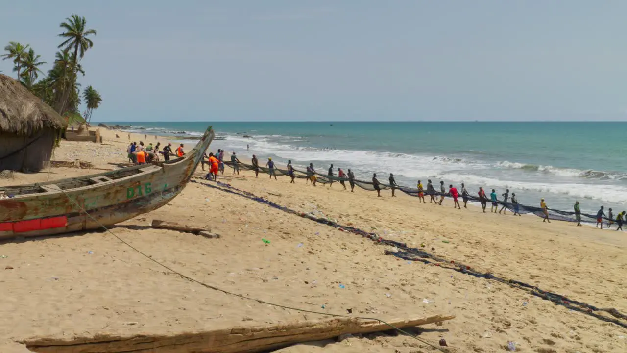 African people pulling the fishing nets out of the sea on the coast of Ghana