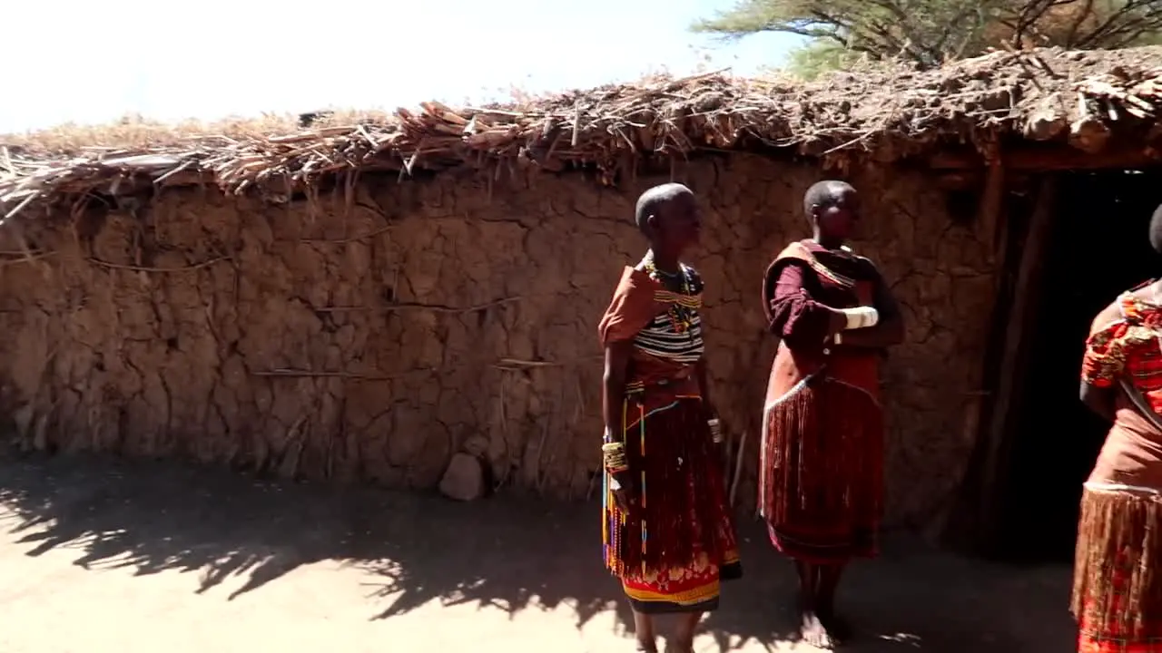 Datoga tribe women in traditional colorful clothing waiting to welcome tourists