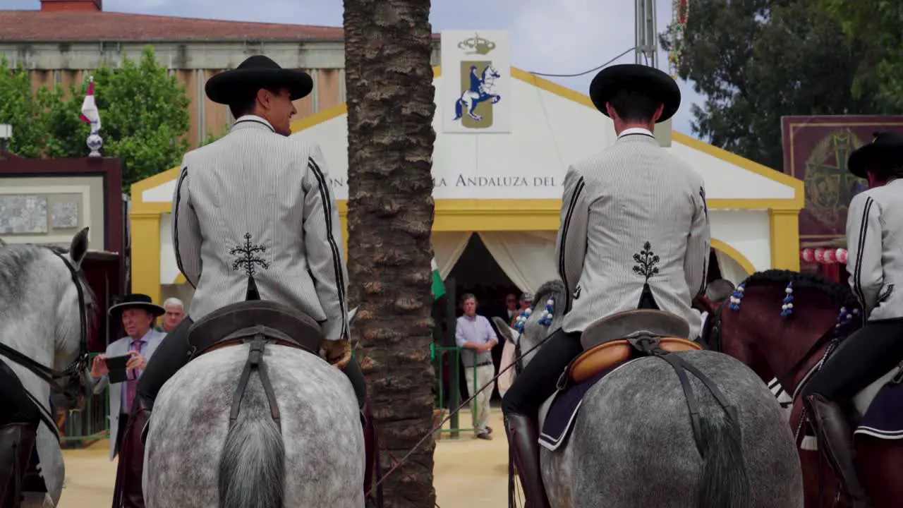 Spanish men sit on horses outside the Real Escuela Andaluza de Del Arte Ecuestre caseta in Jerez de la Frontera Spain