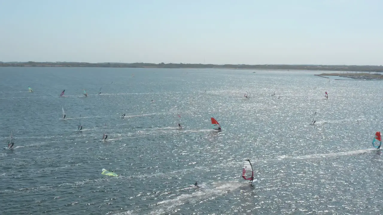 Drone Aerial shot of many surfers on a blue wavy and windy sea on a sunny day with white clouds on a island Zeeland Netherlands 25p