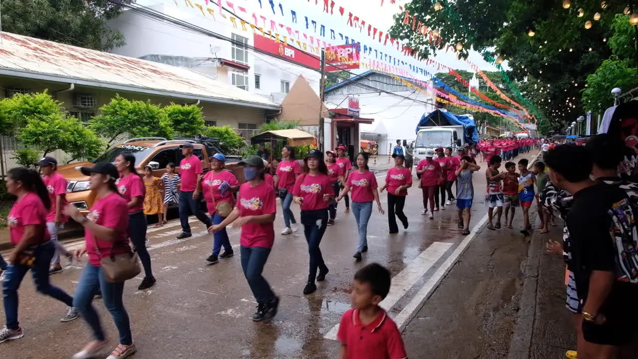 Filipino crowds of people wearing bright colors singing and dancing during Pintados Kasadyaan festival celebrations in Coron Town in Palawan Philippines Southeast Asia