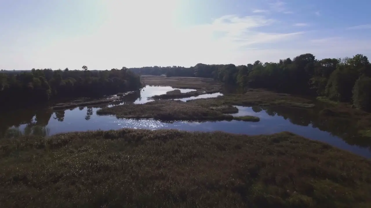 Flying Low Backwards Over The Winding River on a Sunny Morning