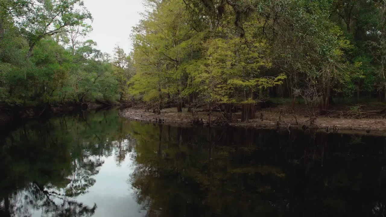 Quiet peaceful serene slowly running river with sky and tree reflections